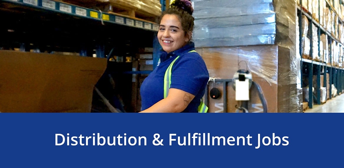 A smiling employee in a JYSK warehouse wearing a safety vest above the words 'Distribution & Fulfillment Jobs.