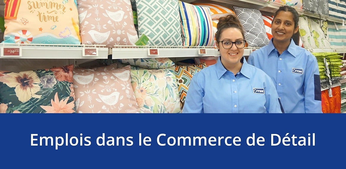 Deux employés de JYSK debout à côté de la section des coussins dans l'un des magasins de JYSK Canada, au-dessus des mots 'Emplois dans le Commerce de Détail.'