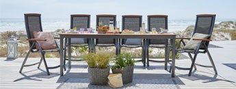 Sustainable furniture from JYSK, including FSC certified wood table with chairs on a deck outdoor