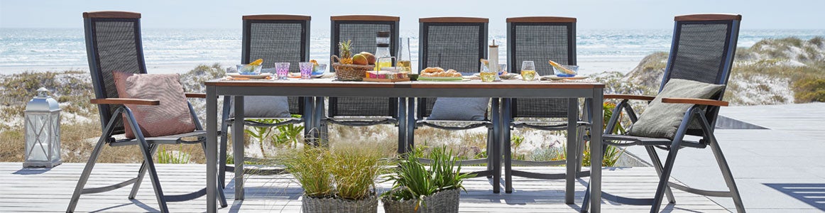Sustainable furniture from JYSK, including FSC certified wood table with chairs on a deck outdoors