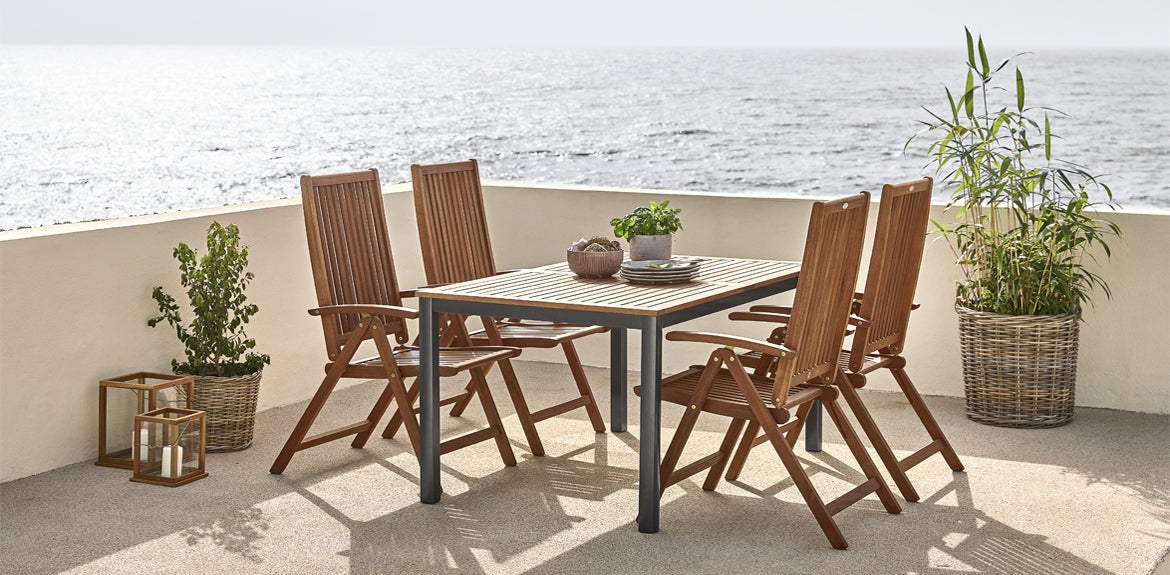 Sustainable furniture from JYSK Canada including the FSC certified dining table and chairs on a patio by the ocean
