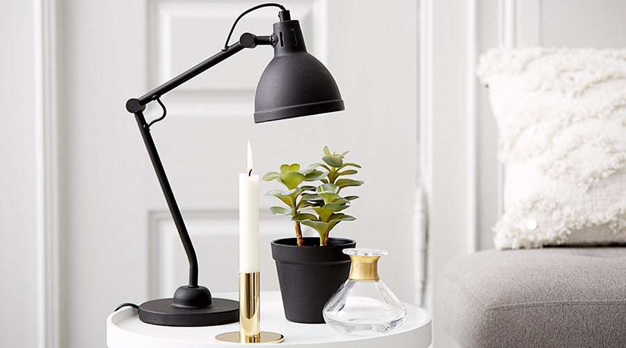black lamp and candle on a bedside table
