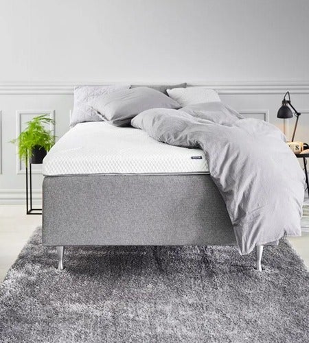 surmatelas rafraîchissant présenté sur un cadre de lit simple